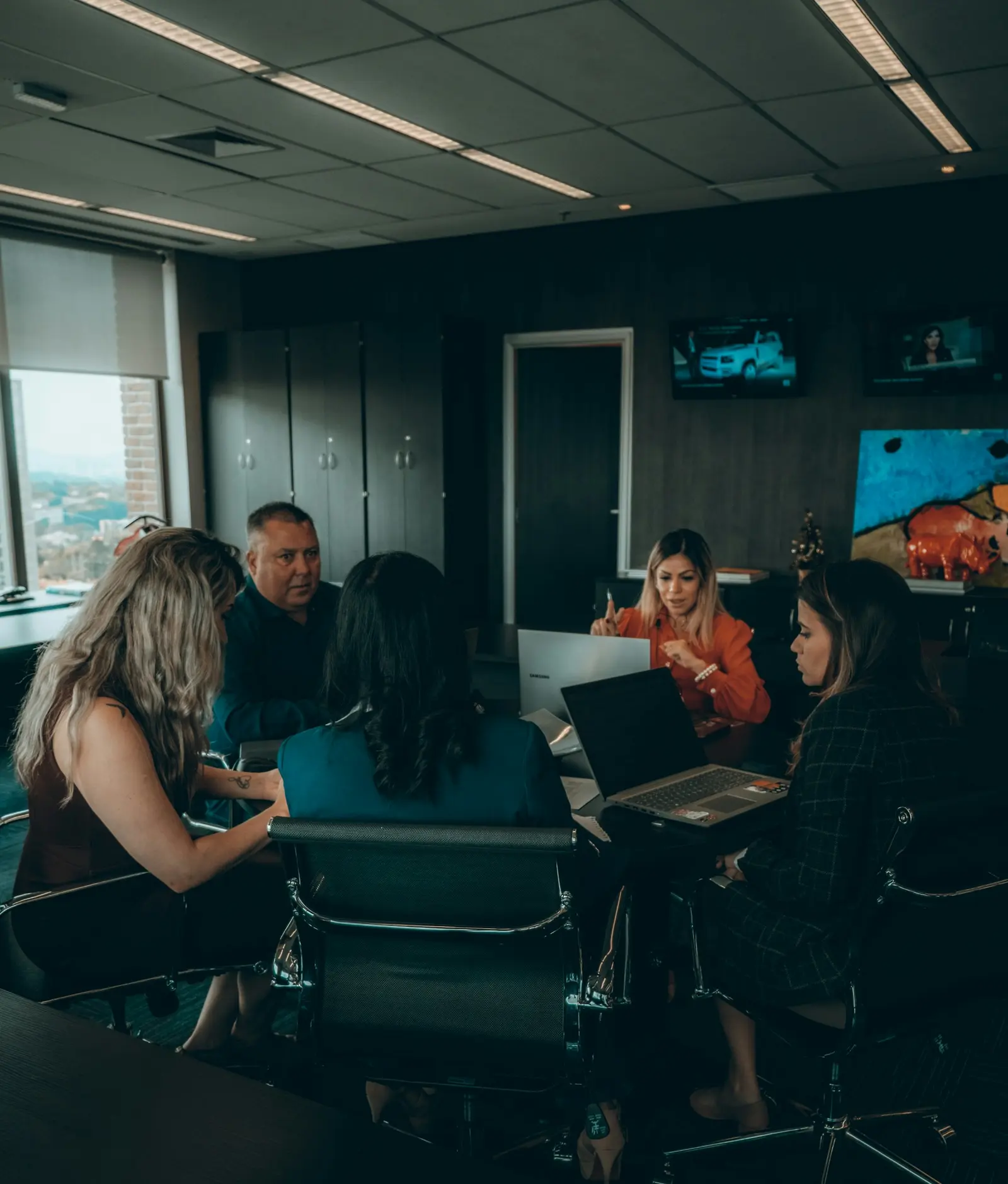 Professionals collaborating around a table with laptops